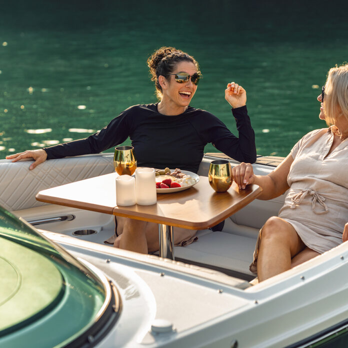 Two women sitting in the bow of an SDX 230