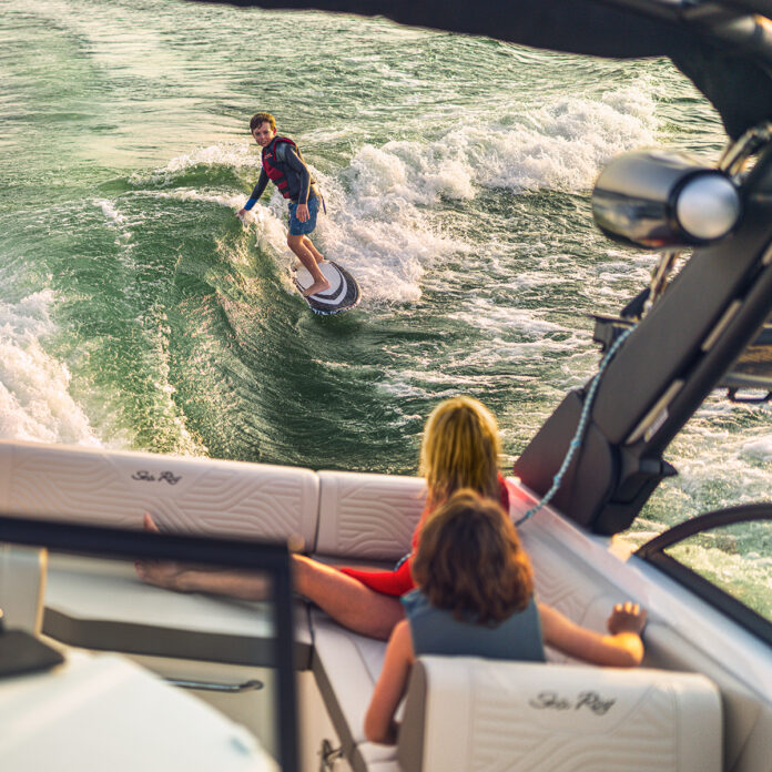 Kid wakesurfing behind an SDX 230 Surf